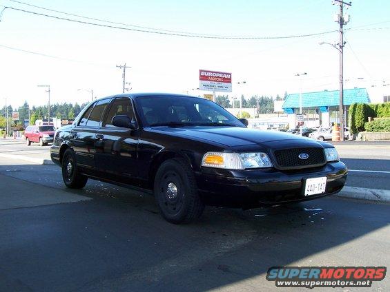 Black 2003 Ford Crown Victoria with a black grille and license plate 440-TAT