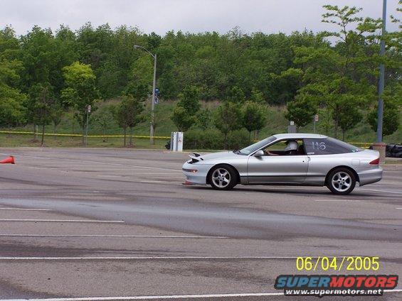 Silver 1993 Ford Probe driving on a track with a number 116 on the window