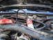 1988 Ford Bronco - A can of carburetor cleaner is attached to a hose in the engine bay of a vehicle.