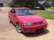 2002 Nissan SE-R - A red sedan is parked in a suburban driveway on a sunny day.