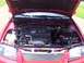2002 Nissan SE-R - The engine bay of a red 2002 Nissan SE-R is visible with the hood raised, revealing the 2.5L engine and front grille.