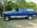 1995 Ford C-350 (Centurion Conversions) - This blue extended cab pickup truck features a camper shell and a prominent bull bar on the front.