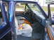 1995 Ford C-350 (Centurion Conversions) - Interior view of a blue vehicle, showing the dashboard, seats, and door panel with wood accents.