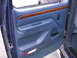 1995 Ford C-350 (Centurion Conversions) - Interior door panel of a 1995 Ford C-350 (Centurion Conversions) shows blue upholstery and wood accents.