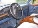 1995 Ford C-350 (Centurion Conversions) - The interior of a blue Ford truck, a wooden center console and dashboard details.