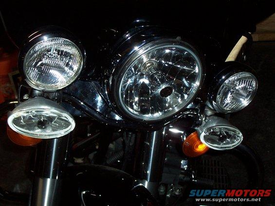 Black motorcycle front end with triple headlights and orange turn signals