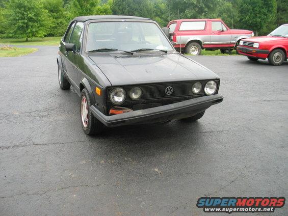 Black convertible with red trim wheels, front view. 1986 Volkswagen Cabriolet