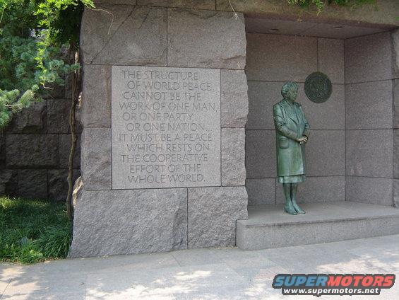 Statue of Eleanor Roosevelt next to a stone wall with a quote about world peace