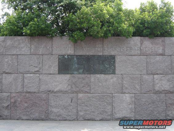 Stone wall with inscription 'THE ONLY THING WE HAVE TO FEAR IS FEAR ITSELF' and a bronze relief panel