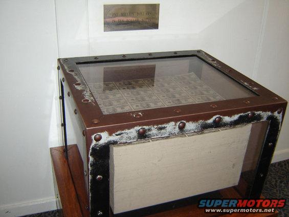 Display case filled with ten dollar bills, with a sign above reading 'ONE MILLION DOLLARS IN TEN DOLLAR NOTES'