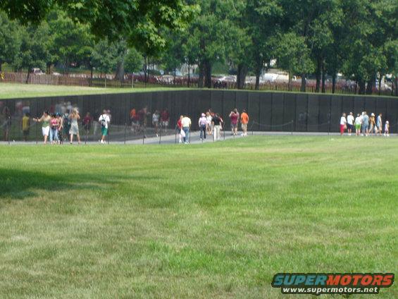 Vietnam Veterans Memorial wall with visitors on a sunny day