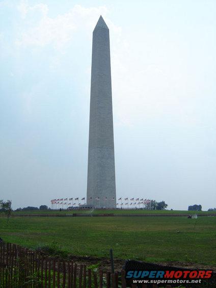 Washington Monument with flags and a grassy field in the foreground