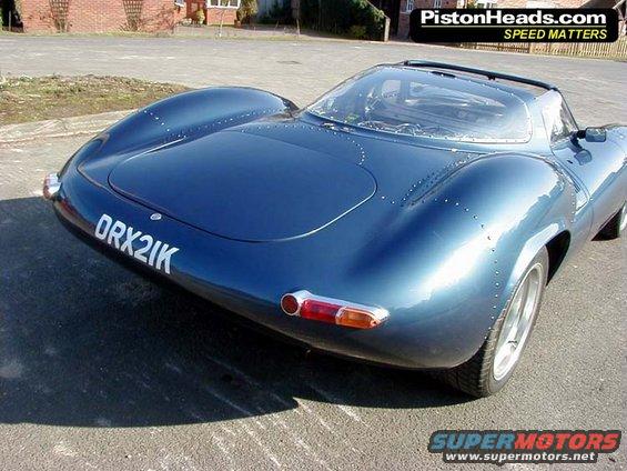 Blue sports car with riveted body panels and license plate DRX2IK, rear view