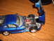 1988 Ford Bronco - A blue toy car's engine is exposed on a wooden table.