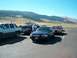 2001 Ford Crown Victoria - Several vehicles are parked in a lot with a mountainous landscape under a clear blue sky.