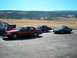 2001 Ford Crown Victoria - A red 2001 Ford Crown Victoria is parked alongside other vehicles under a clear blue sky.