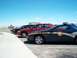 2001 Ford Crown Victoria - Several law enforcement vehicles are parked in a lot under a clear blue sky.