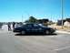 2001 Ford Crown Victoria - A black 2001 Ford Crown Victoria police car, marked 'Town Marshal', is parked in a lot on a sunny day.