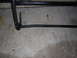 1995 Ford Bronco - A black metal brush guard is shown from a low angle, resting on a concrete surface.