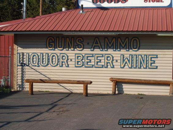 Storefront with signs for guns, ammo, liquor, beer, and wine