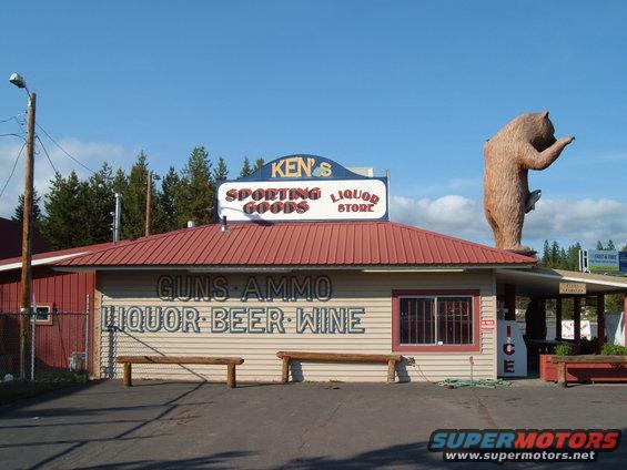 Store with large bear statue and signs for sporting goods, liquor, beer, and wine
