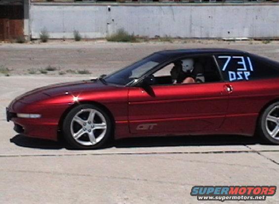 Side view of a red 1996 Ford Probe with racing numbers 731 DSP on the rear window