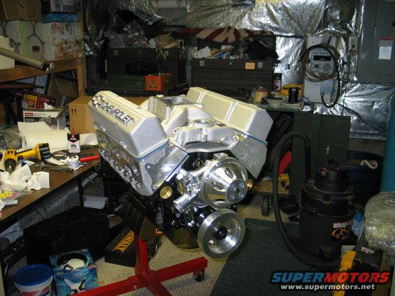 Chevrolet V8 engine on an engine stand in a cluttered garage