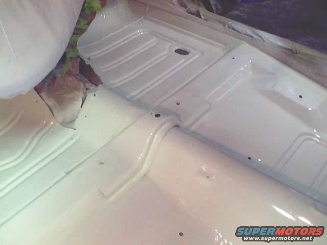 White painted floor pan with ribbed texture and visible holes