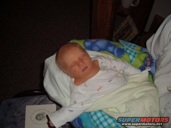 Sleeping baby wrapped in blankets, with a drawing of a baby nearby
