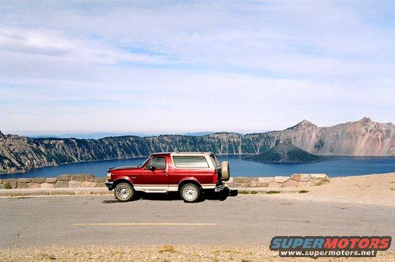 Red SUV parked overlooking Crater Lake, 1990s model