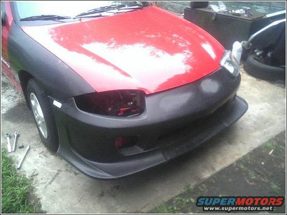 red car front end with black fender flares and bumper cover, looks like work in progress