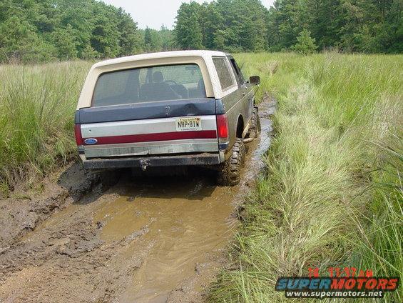 Ford Bronco stuck in a muddy trail, rear view