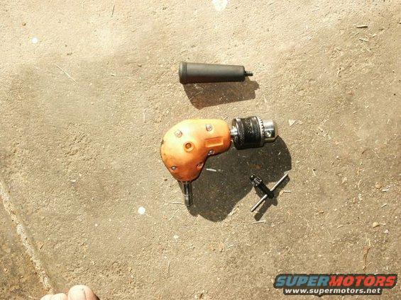 Right angle drill with chuck and chuck key on concrete