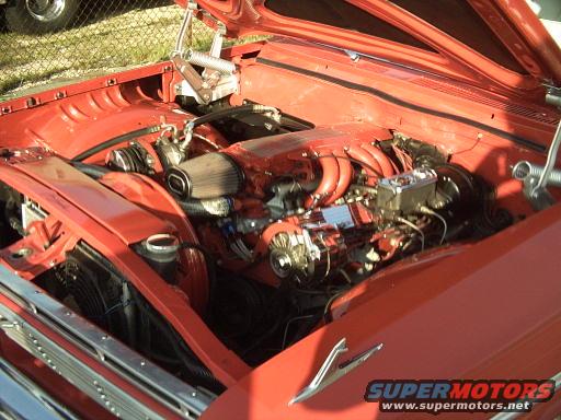Red engine bay with chrome accents and aftermarket air filter. Supermotors.net logo visible