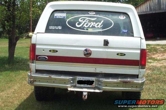 Rear view of a white Ford Bronco with a red stripe. Has a Ford oval sticker on the rear window and a Tennessee license plate