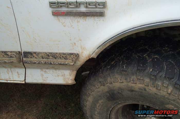 White 1988 Ford Bronco side view with mud splatter and 'Bronco' badge