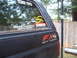 1988 Ford Bronco - A black 1988 Ford Bronco is shown from the rear quarter panel, off-road decals and various stickers on the rear window.