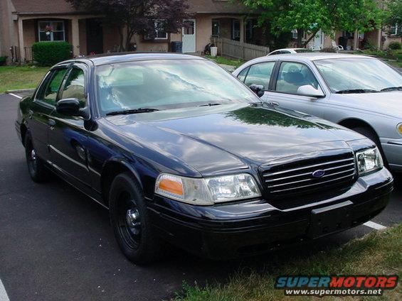 Black Ford Crown Victoria parked next to a silver sedan