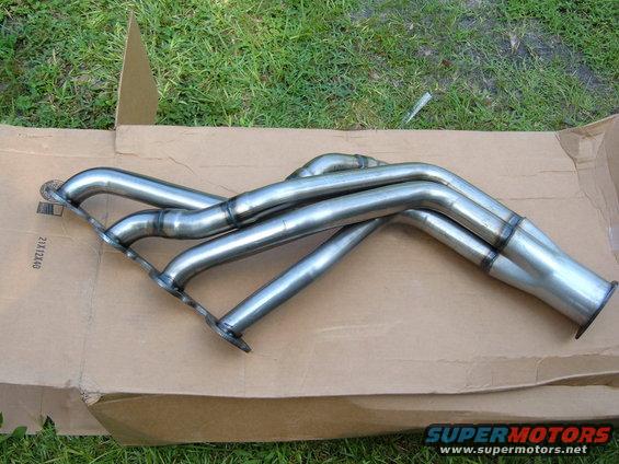 Stainless steel exhaust headers on a cardboard box