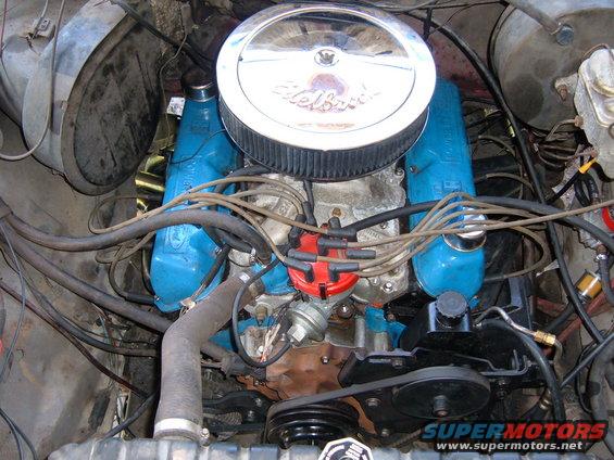 Close-up of a blue Ford V8 engine with a chrome air cleaner and red distributor cap
