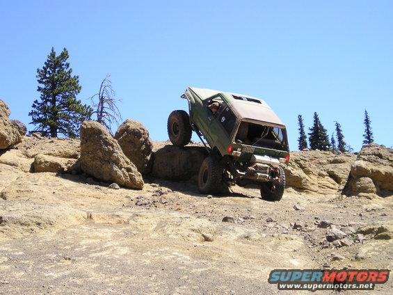 1989 Ford Bronco climbing over large rocks on an off-road trail