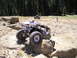 1989 Ford Bronco - Off-road vehicles navigate a rocky trail in a wooded area.