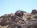 1989 Ford Bronco - Off-road vehicles navigate a challenging rocky terrain under a clear blue sky.