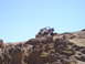 1989 Ford Bronco - A white 1989 Ford Bronco navigates a steep, rocky incline under a clear blue sky.