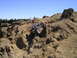 1989 Ford Bronco - A custom off-road vehicle navigates a challenging rocky terrain on a sunny day.
