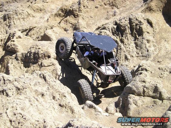 Black off-road buggy navigating rocky terrain