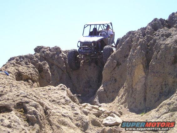 Buggy driving over rocky terrain with a person inside