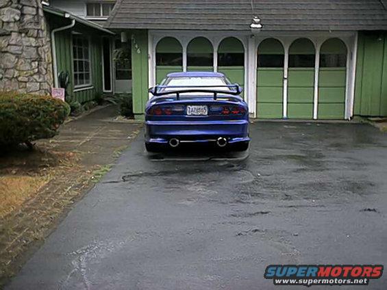 Blue 1993 Ford Mustang Cobra rear view, parked in driveway. License plate 7AZB665