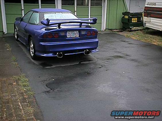 Blue 1993 Ford Probe with a spoiler and dual exhaust pipes parked in a driveway
