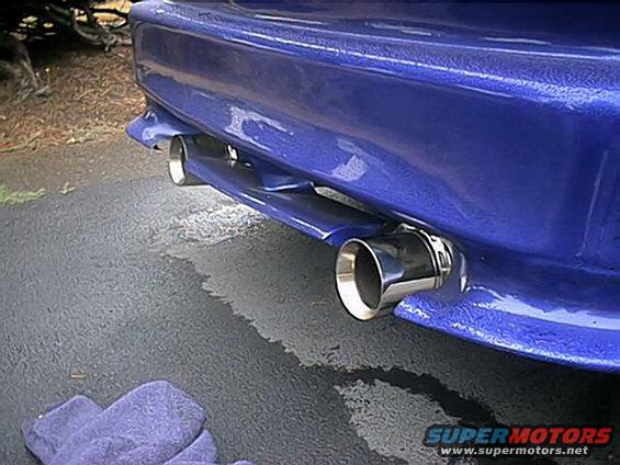 Blue car rear bumper with dual chrome exhaust tips visible